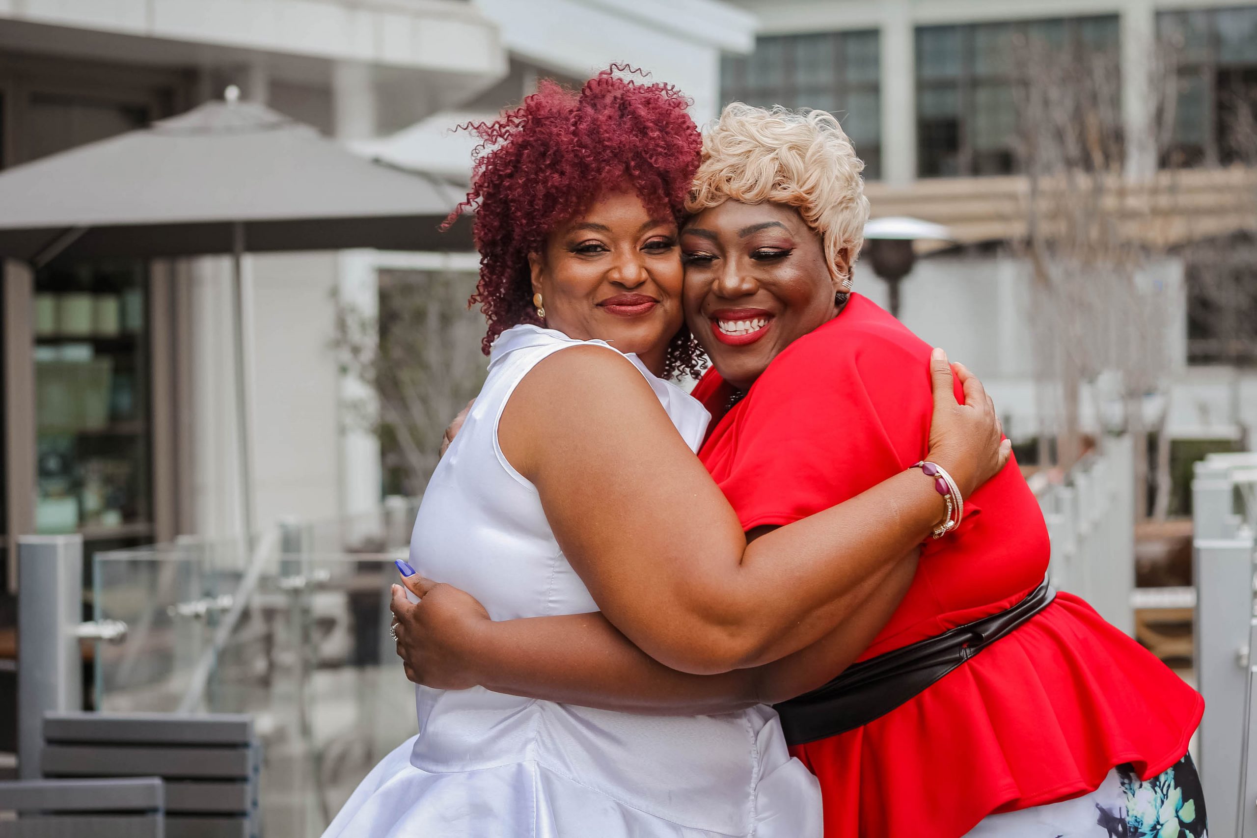 Two plus-size Black women hugging and smiling